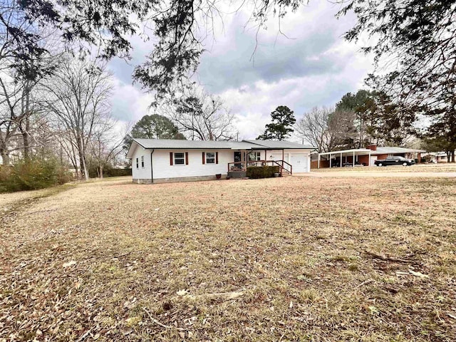 ranch-style house featuring a carport, a garage, a porch, and a front lawn