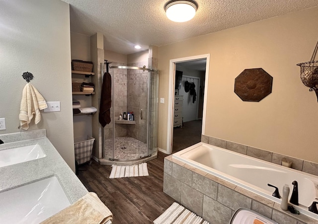 bathroom featuring vanity, wood-type flooring, independent shower and bath, and a textured ceiling