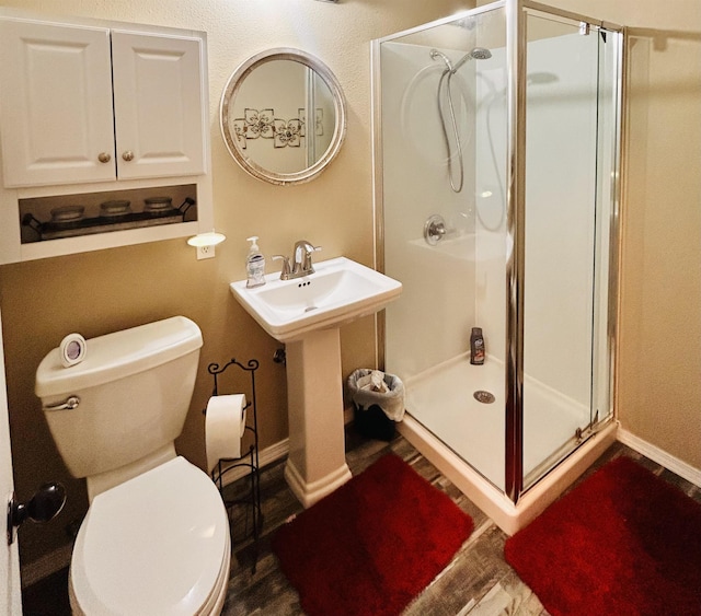 bathroom with toilet and a shower with shower door