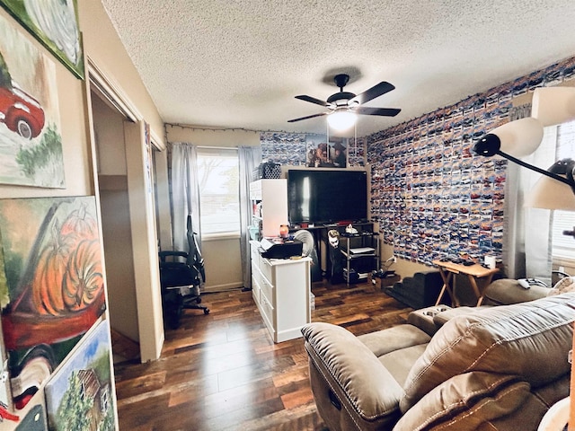 living room with ceiling fan, dark hardwood / wood-style floors, and a textured ceiling