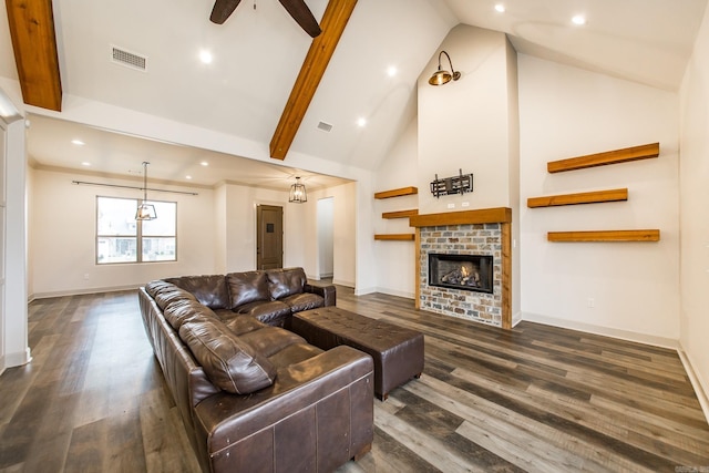 living room with dark wood-type flooring, ceiling fan, high vaulted ceiling, and a brick fireplace