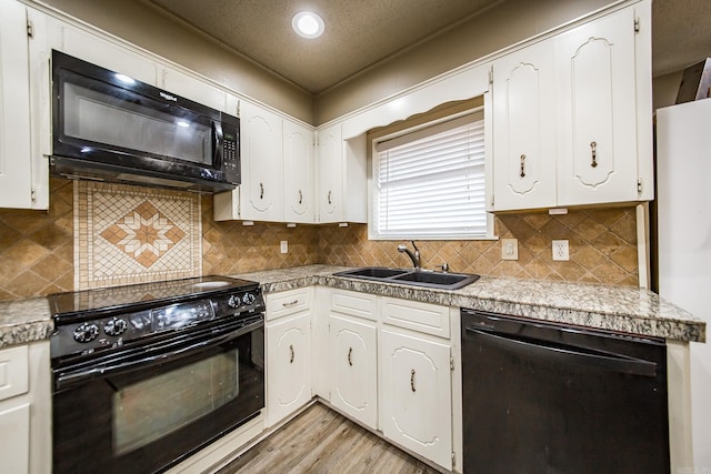 kitchen featuring sink, black appliances, a textured ceiling, white cabinets, and light wood-type flooring