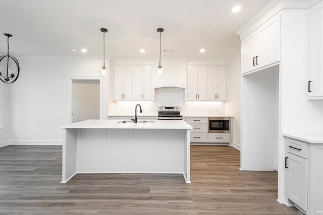 kitchen featuring electric stove, white cabinetry, a kitchen island with sink, built in microwave, and decorative light fixtures