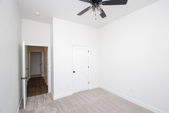 unfurnished bedroom featuring ceiling fan, a closet, and light carpet