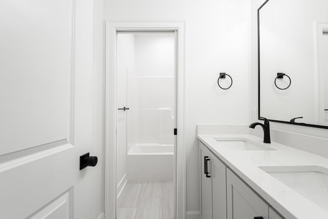 bathroom featuring vanity and  shower combination