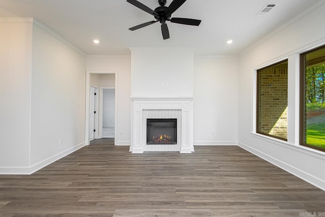 unfurnished living room with ceiling fan, a fireplace, ornamental molding, and dark hardwood / wood-style flooring