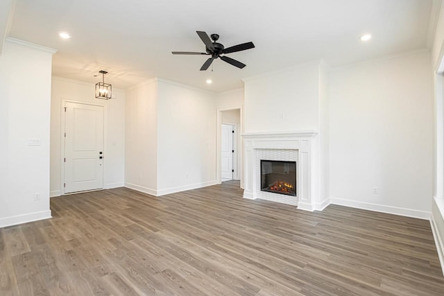 unfurnished living room featuring wood-type flooring, ceiling fan, and crown molding