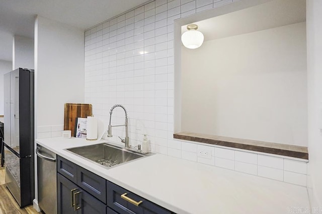 kitchen featuring sink, tasteful backsplash, light hardwood / wood-style floors, black fridge, and stainless steel dishwasher