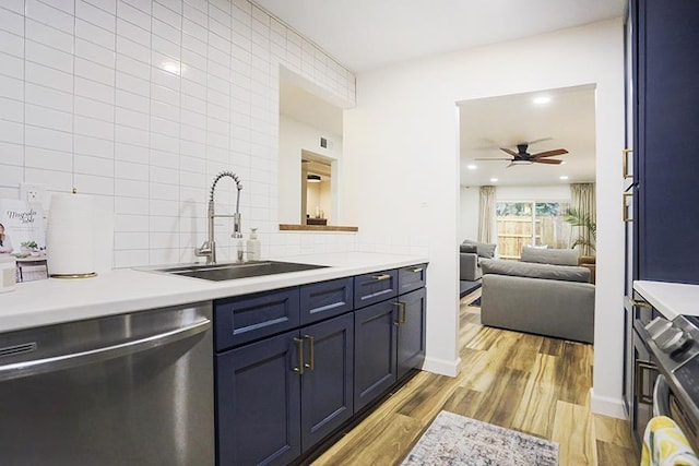 kitchen featuring blue cabinetry, sink, stainless steel dishwasher, light hardwood / wood-style floors, and decorative backsplash