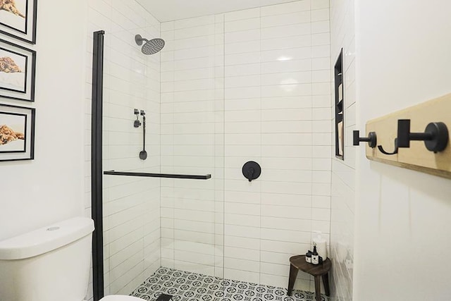 bathroom with tiled shower and toilet