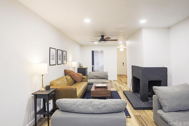 living room featuring light hardwood / wood-style flooring and ceiling fan
