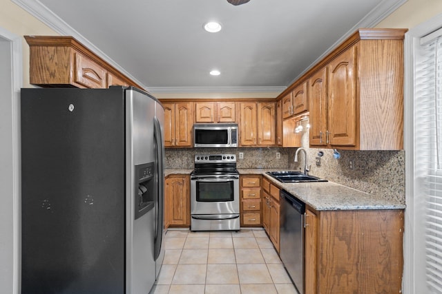 kitchen featuring sink, ornamental molding, light stone countertops, and appliances with stainless steel finishes