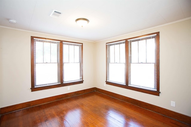 unfurnished room with hardwood / wood-style flooring, crown molding, and plenty of natural light