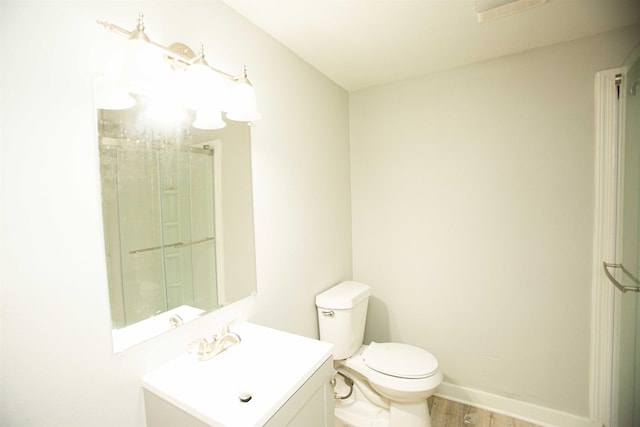 bathroom featuring vanity, hardwood / wood-style flooring, and toilet