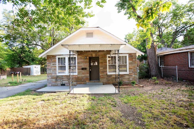 bungalow-style home featuring a shed, a patio, and a front yard