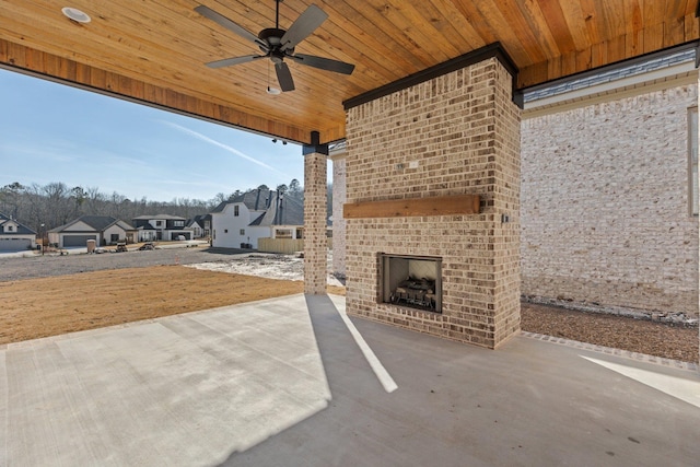 view of patio / terrace featuring an outdoor brick fireplace, a residential view, and a ceiling fan