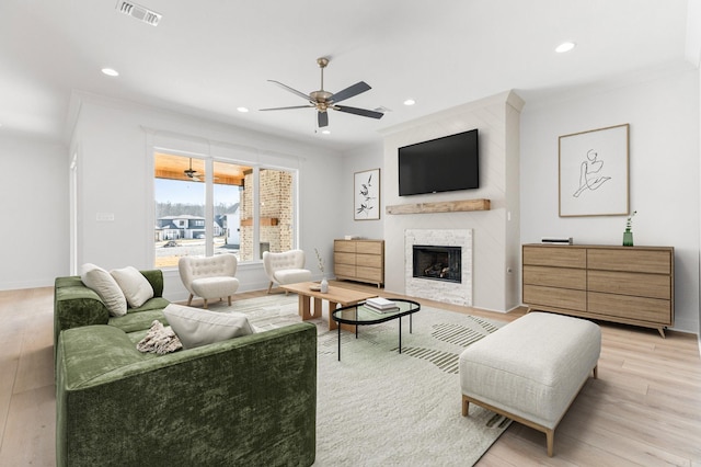 living room with recessed lighting, a fireplace, visible vents, a ceiling fan, and light wood finished floors