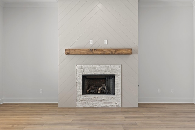 details featuring crown molding, a fireplace, baseboards, and wood finished floors