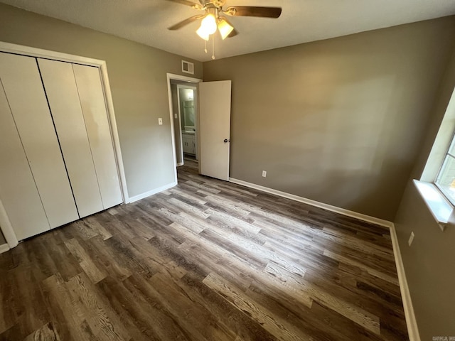 unfurnished bedroom featuring wood-type flooring, ceiling fan, and a closet