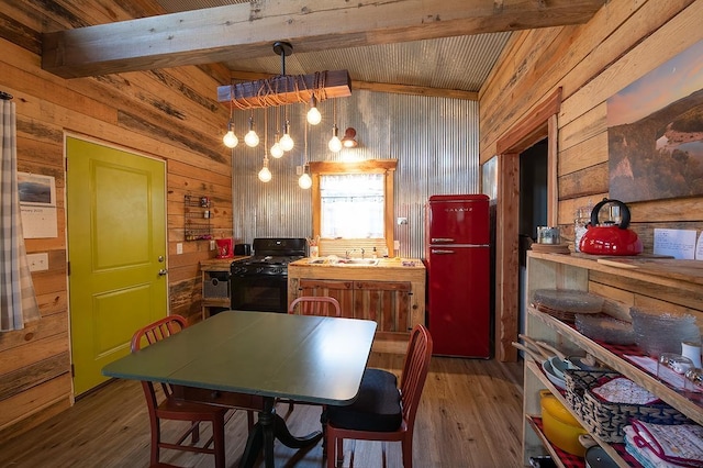 kitchen featuring black range with gas cooktop, butcher block countertops, wood-type flooring, wooden walls, and beamed ceiling