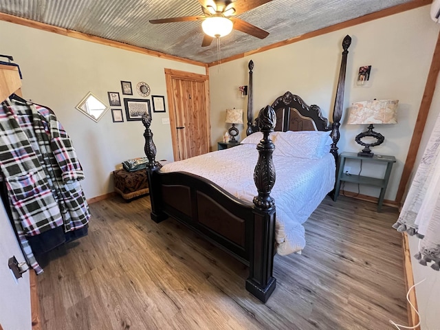 bedroom with hardwood / wood-style flooring, ceiling fan, and crown molding