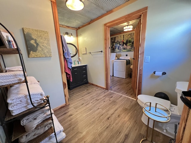 bathroom featuring hardwood / wood-style flooring, vanity, and separate washer and dryer