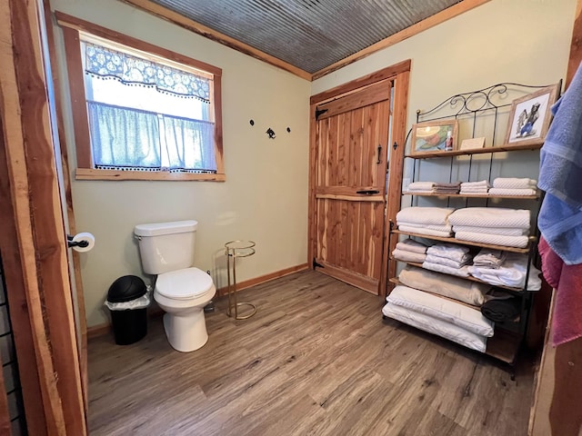 bathroom featuring crown molding, wood-type flooring, and toilet