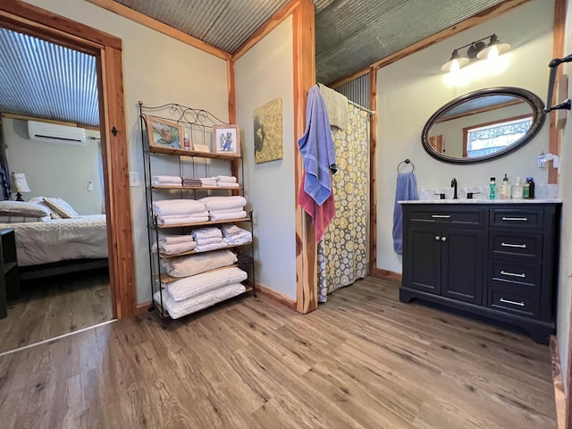 bathroom featuring wood-type flooring, an AC wall unit, and vanity