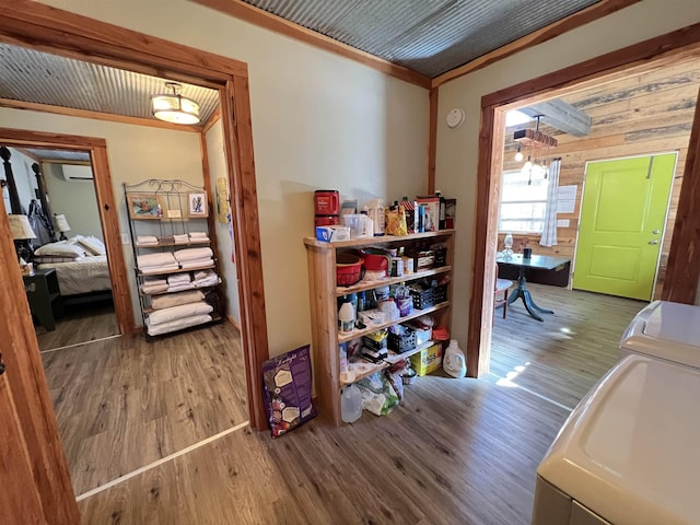 corridor featuring ornamental molding, washer and dryer, and hardwood / wood-style floors