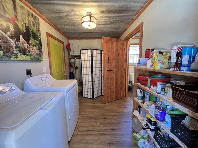 clothes washing area with wood ceiling, wood-type flooring, crown molding, and washing machine and dryer