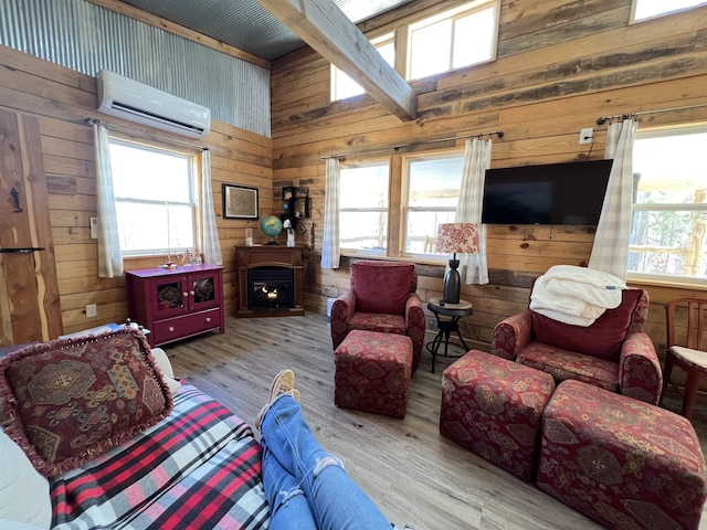 living room with wooden walls, an AC wall unit, and light wood-type flooring