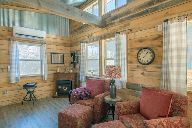 living room featuring a towering ceiling, wooden walls, a wall unit AC, light hardwood / wood-style floors, and beam ceiling