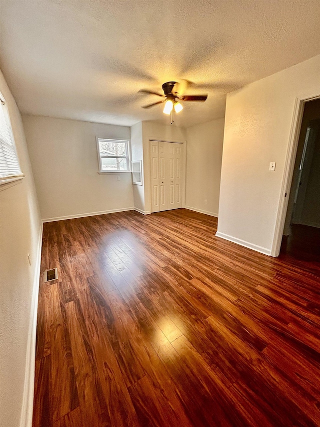 spare room featuring a textured ceiling, dark hardwood / wood-style floors, and ceiling fan