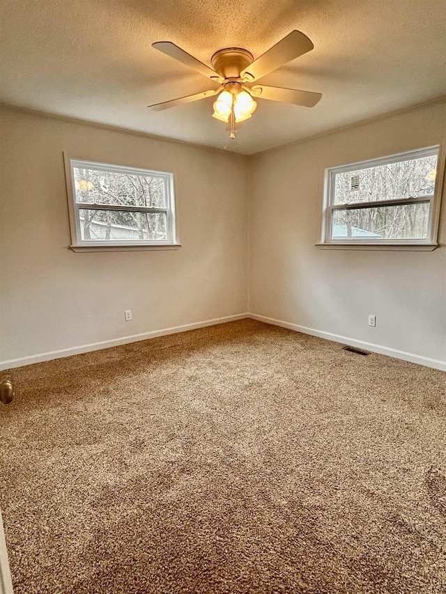 carpeted spare room featuring ceiling fan and a textured ceiling