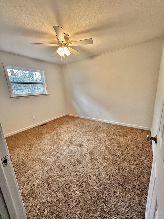 carpeted spare room with ceiling fan and a textured ceiling
