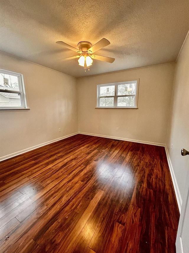 unfurnished room with dark hardwood / wood-style floors, a wealth of natural light, and ceiling fan