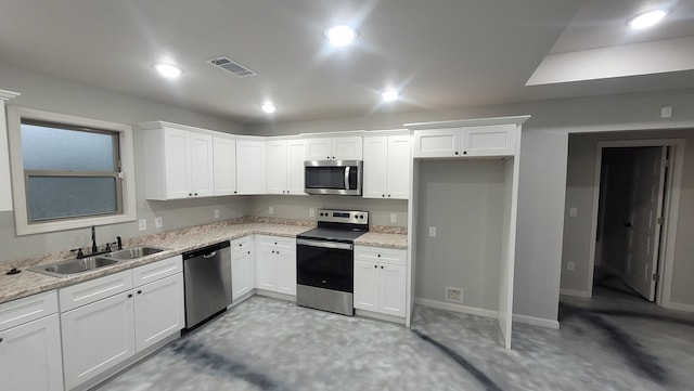 kitchen with appliances with stainless steel finishes, a sink, visible vents, and white cabinetry