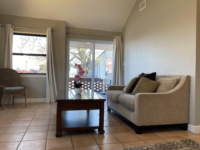 living room with tile patterned flooring and vaulted ceiling