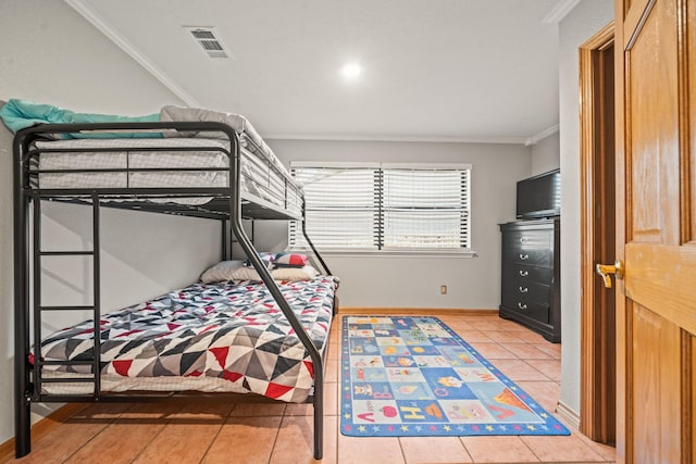 bedroom with ornamental molding and tile patterned floors