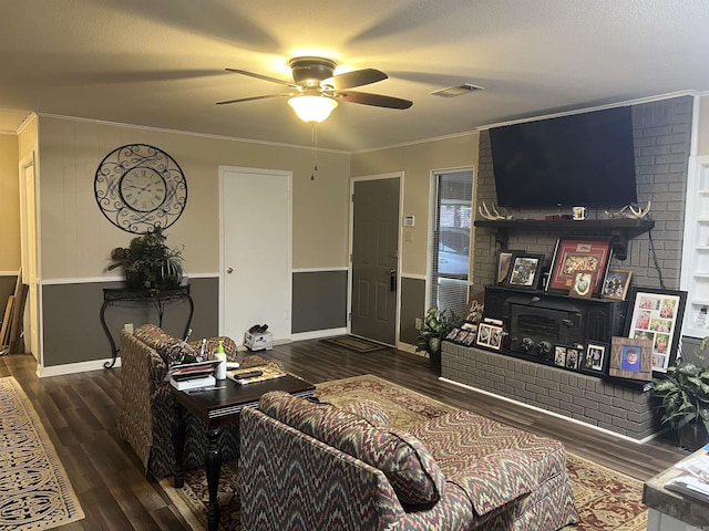 living room featuring ornamental molding, dark wood-type flooring, a fireplace, and ceiling fan