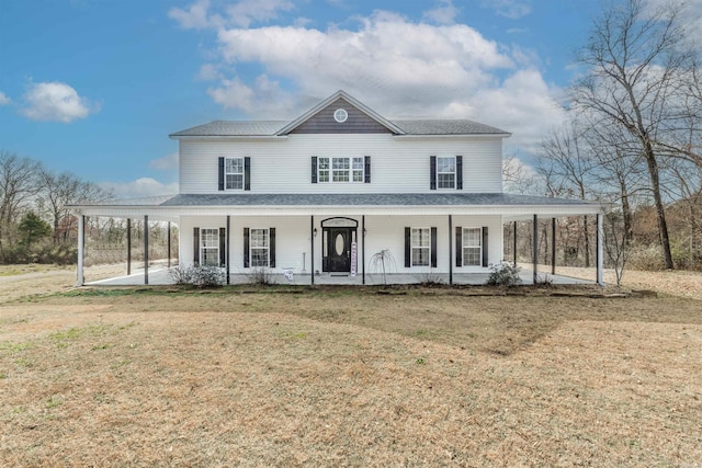 farmhouse-style home featuring covered porch, a front lawn, and a shingled roof