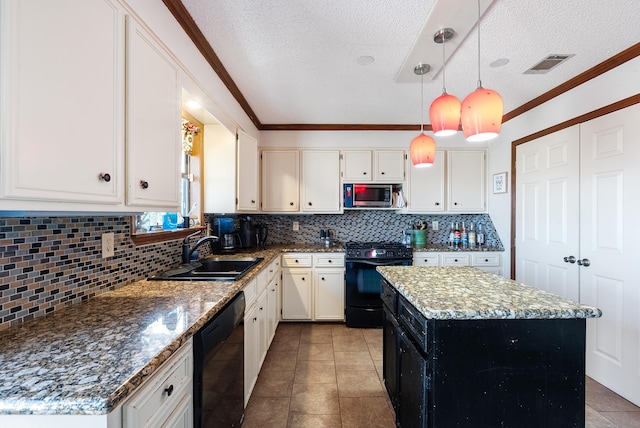 kitchen with sink, hanging light fixtures, a center island, light stone counters, and black appliances