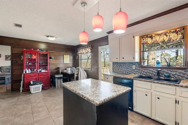 kitchen featuring pendant lighting, sink, dishwasher, white cabinetry, and a kitchen island