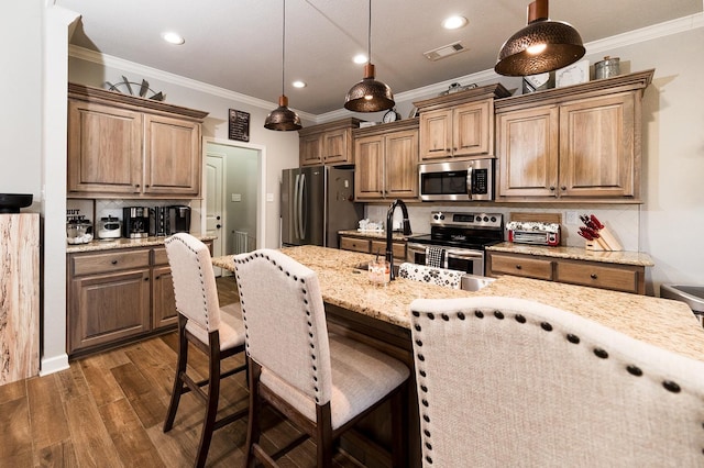 kitchen featuring tasteful backsplash, decorative light fixtures, appliances with stainless steel finishes, dark hardwood / wood-style floors, and light stone countertops