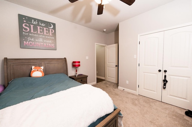 bedroom featuring light colored carpet, ceiling fan, and a closet