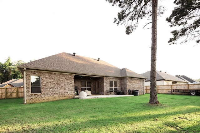 rear view of property featuring a patio and a yard