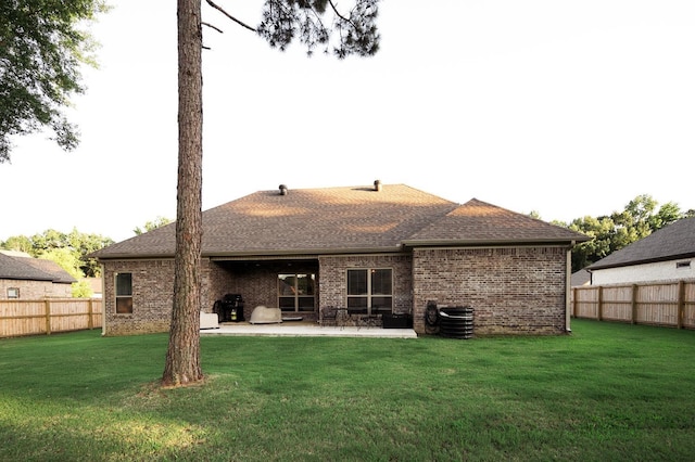 rear view of property with a yard, a patio area, and central air condition unit