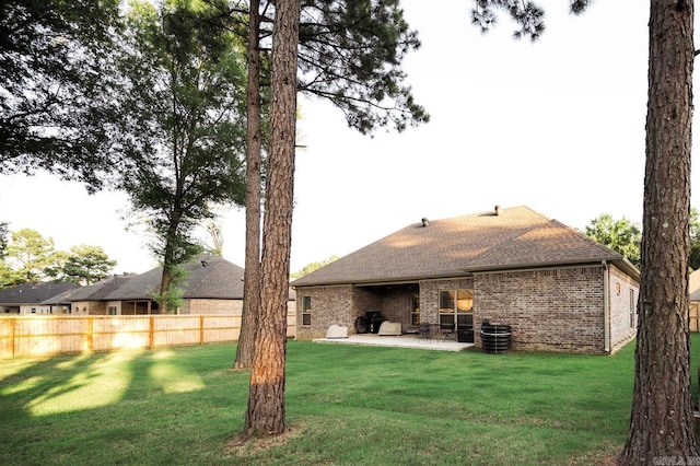 rear view of house with a patio area, a lawn, and central air condition unit