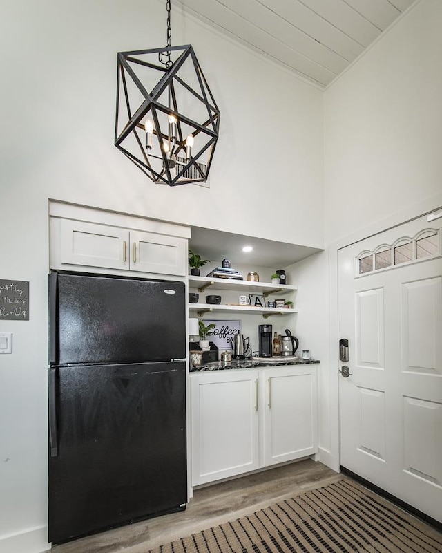 bar with black fridge, pendant lighting, dark hardwood / wood-style flooring, and white cabinets