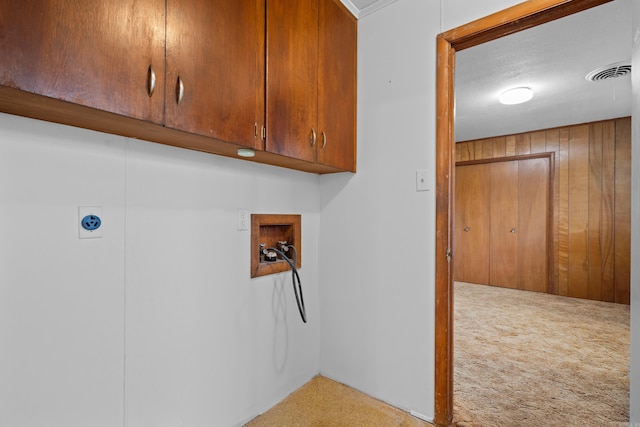 laundry room featuring wood walls, hookup for a washing machine, cabinets, and carpet flooring